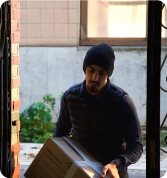 Déménageur Grondin portant un carton à l'entrée d'un logement parisien
